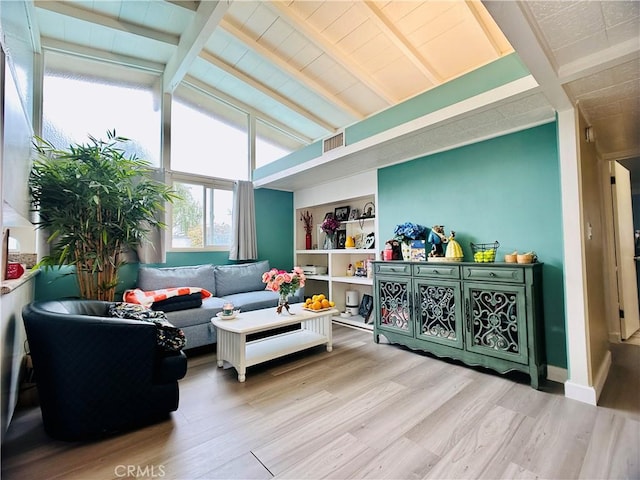 living room featuring lofted ceiling with beams and light wood-type flooring