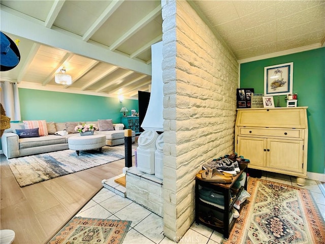 interior space with ornamental molding, light hardwood / wood-style floors, and vaulted ceiling with beams