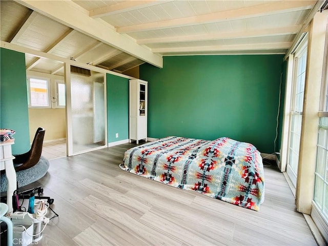 bedroom featuring lofted ceiling with beams and hardwood / wood-style flooring