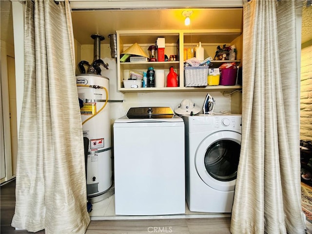 laundry room with water heater and washer and dryer