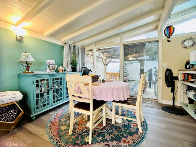 dining room with lofted ceiling with beams and hardwood / wood-style flooring