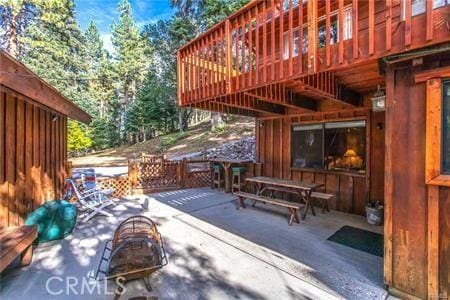 view of patio featuring a wooden deck and a fire pit