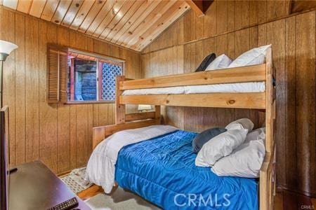 bedroom featuring wood walls, lofted ceiling, and wooden ceiling