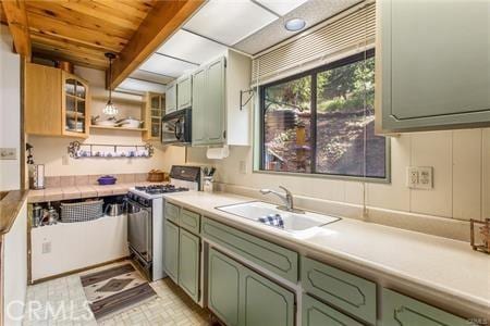 kitchen with beam ceiling, sink, wooden ceiling, and stainless steel gas range