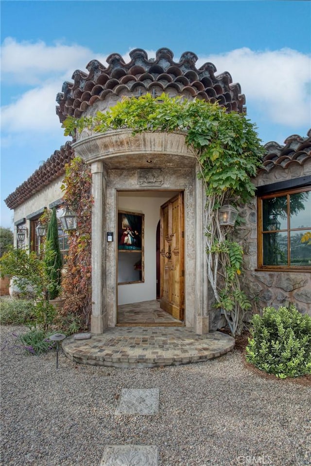 property entrance featuring a tiled roof