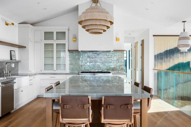 kitchen featuring white cabinets, dishwasher, tasteful backsplash, a kitchen island, and pendant lighting