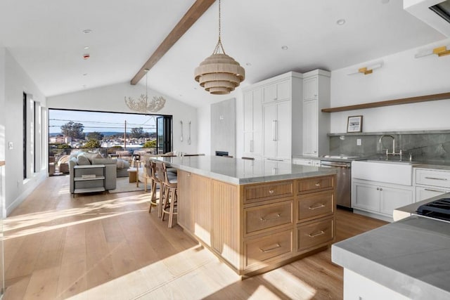 kitchen with white cabinets, dishwasher, light hardwood / wood-style floors, a kitchen island, and pendant lighting