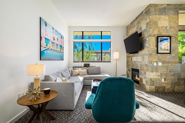 carpeted living room with a stone fireplace