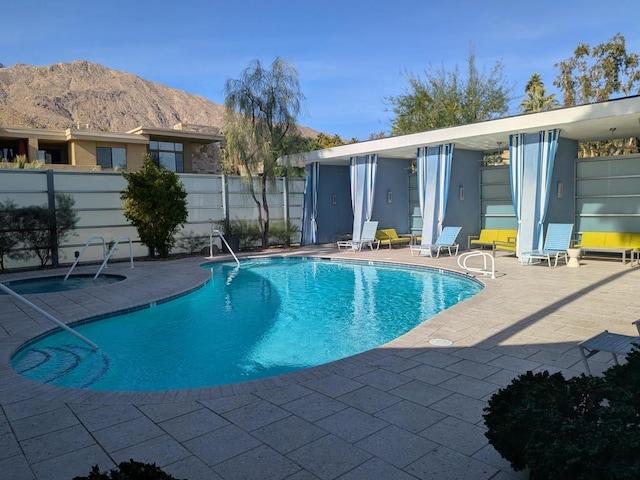 view of swimming pool with a mountain view and a patio area