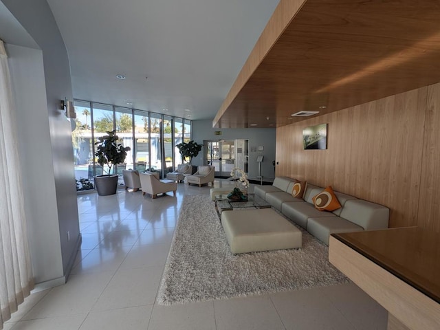 living room with wooden walls, light tile patterned flooring, and wooden ceiling