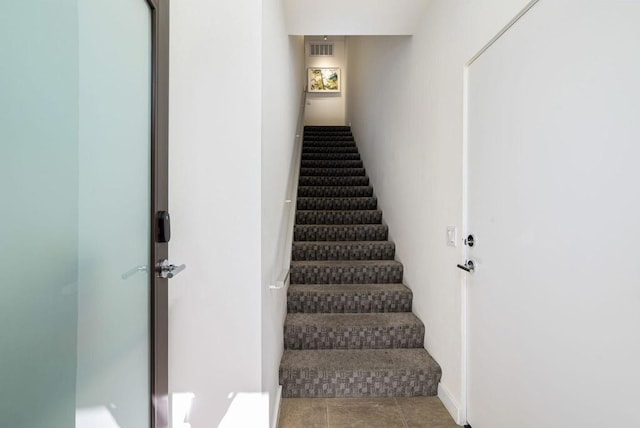 staircase featuring tile patterned flooring