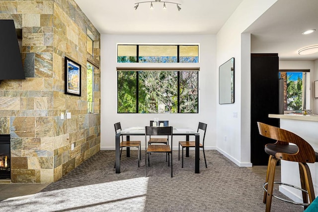 dining space with carpet, tile walls, and a fireplace