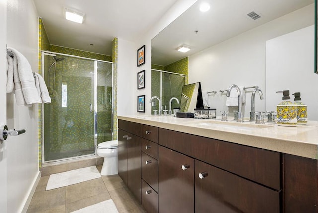 bathroom with tile patterned floors, vanity, toilet, and a shower with door