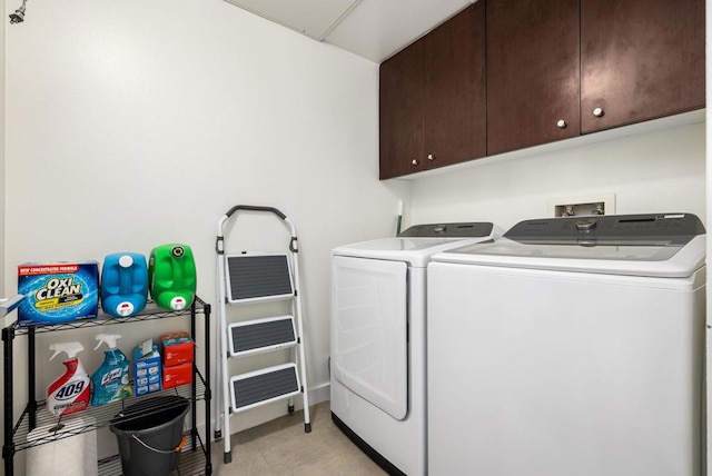 laundry room with washing machine and clothes dryer and cabinets