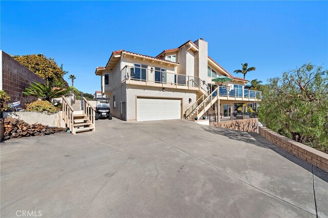 view of front of home with a garage and a balcony