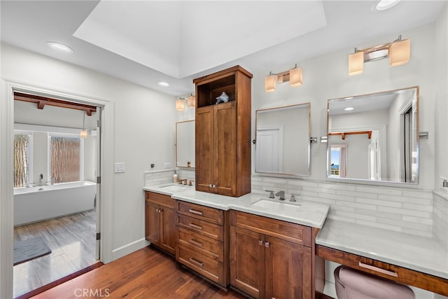 full bath with wood finished floors, backsplash, and a sink