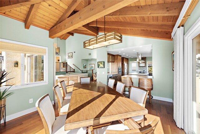 dining area with wood-type flooring, plenty of natural light, vaulted ceiling with beams, and wooden ceiling