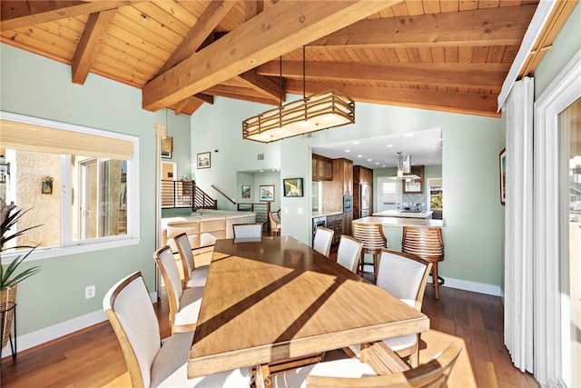 dining space featuring baseboards, wood ceiling, wood finished floors, and vaulted ceiling with beams