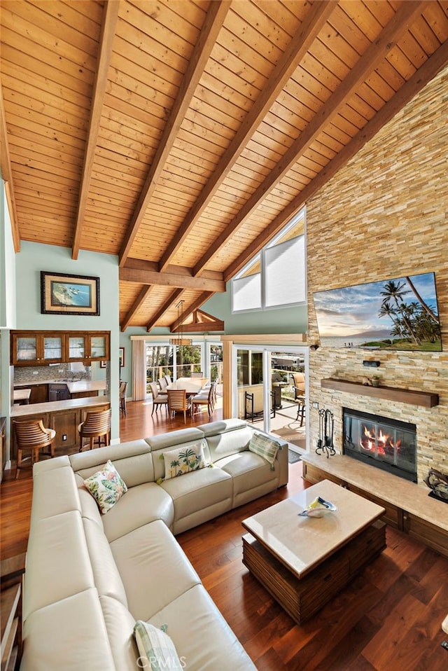 unfurnished living room with wood ceiling, beam ceiling, a fireplace, wood finished floors, and high vaulted ceiling