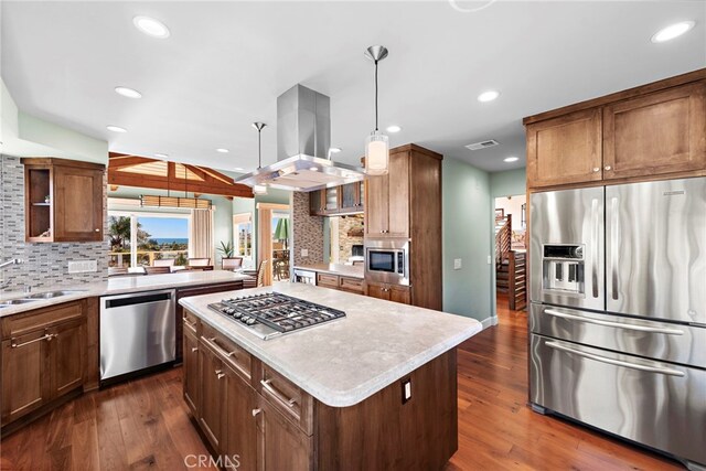 kitchen with pendant lighting, island range hood, sink, a center island, and stainless steel appliances