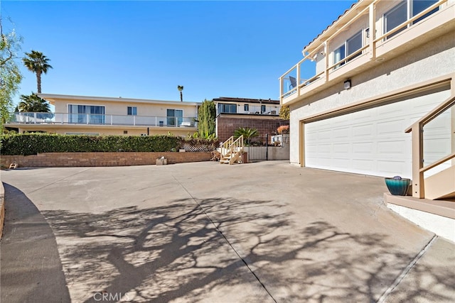 exterior space with a garage, a balcony, and driveway