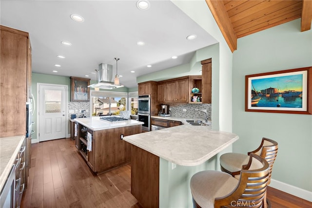 kitchen with ventilation hood, open shelves, double oven, a kitchen breakfast bar, and tasteful backsplash