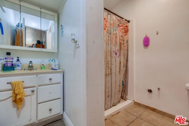 bathroom with a shower with shower curtain, vanity, and tile patterned floors