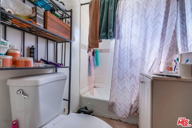 bathroom featuring shower / bath combo with shower curtain and toilet