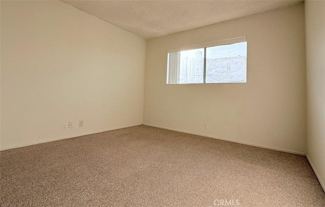 carpeted empty room featuring a textured ceiling