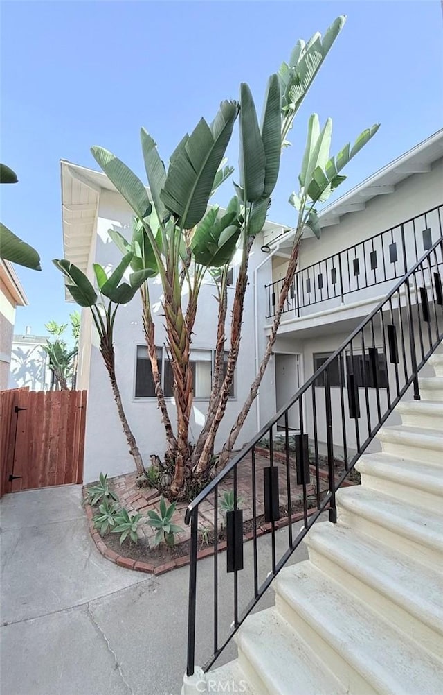 view of building exterior with stairs and fence