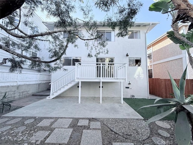 back of house featuring a patio, stucco siding, fence, a deck, and stairs