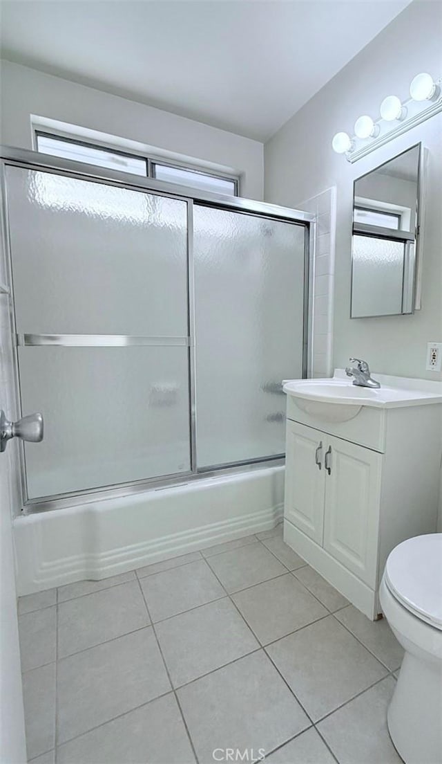 full bathroom with toilet, tile patterned flooring, enclosed tub / shower combo, and vanity