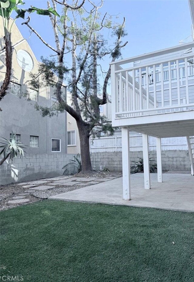 view of yard featuring a patio and a wooden deck