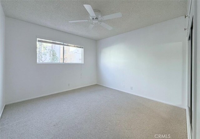 carpeted empty room featuring a textured ceiling and ceiling fan