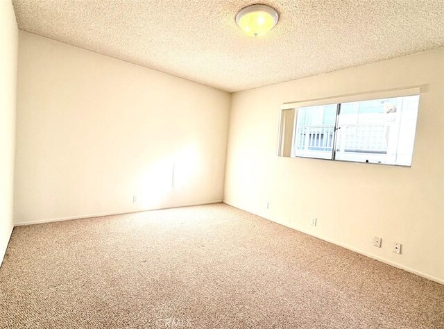 empty room with a textured ceiling and carpet floors