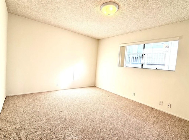 spare room featuring carpet floors and a textured ceiling