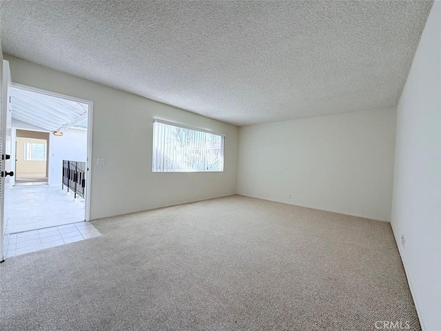 tiled spare room featuring carpet and a textured ceiling