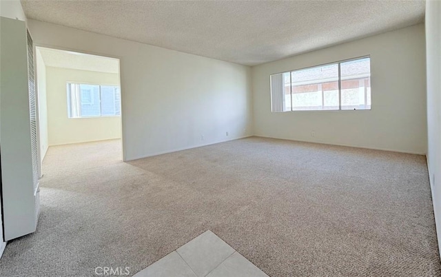 carpeted spare room featuring a textured ceiling