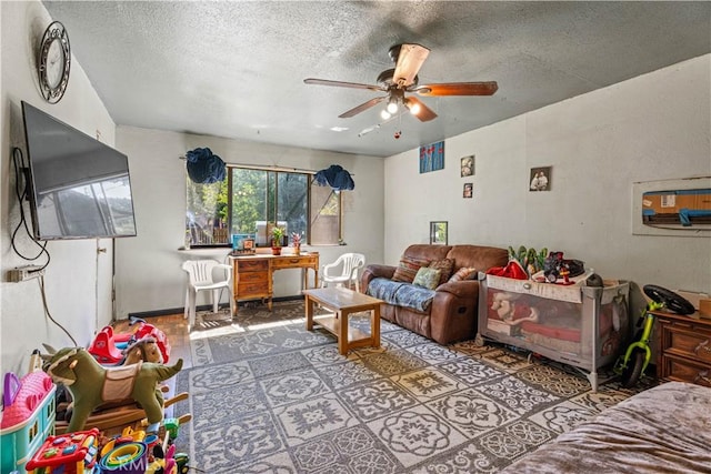 living room featuring ceiling fan and a textured ceiling