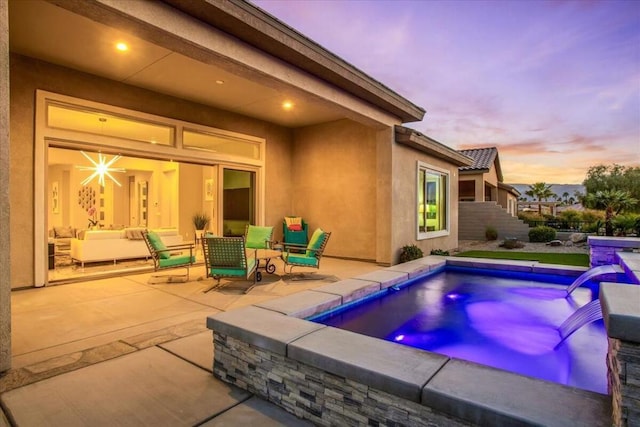 pool at dusk with a patio