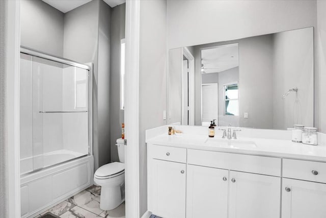 full bathroom featuring vanity, shower / bath combination with glass door, and toilet