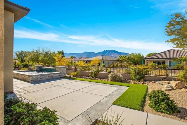 view of patio featuring a mountain view and a jacuzzi