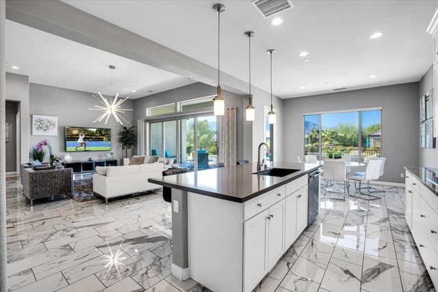 kitchen featuring white cabinetry, sink, pendant lighting, and a healthy amount of sunlight