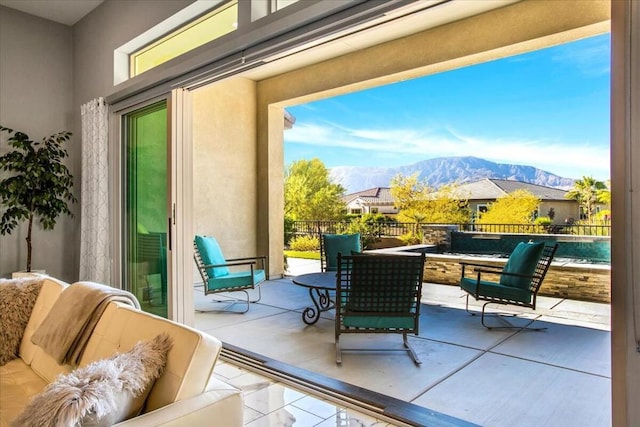 balcony featuring outdoor lounge area, a mountain view, and a patio