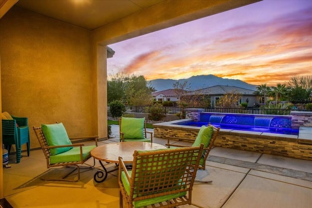 patio terrace at dusk with a jacuzzi and pool water feature