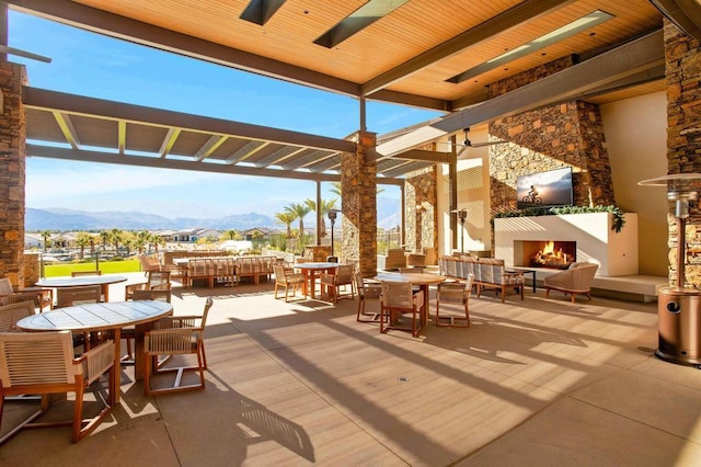 view of patio / terrace with an outdoor living space with a fireplace and a mountain view