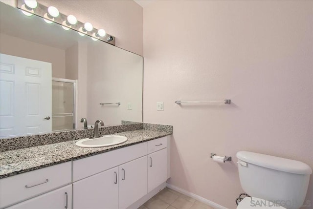 bathroom with toilet, vanity, tile patterned floors, and a shower with door