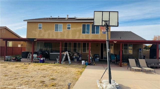 back of property featuring solar panels and a patio