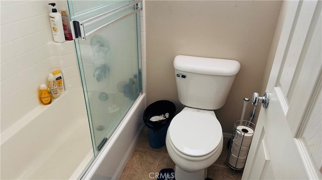 bathroom featuring tile patterned flooring, toilet, and enclosed tub / shower combo