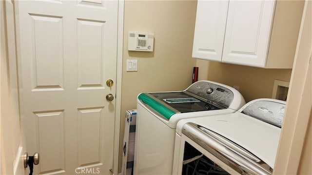 laundry room with washing machine and clothes dryer and cabinets